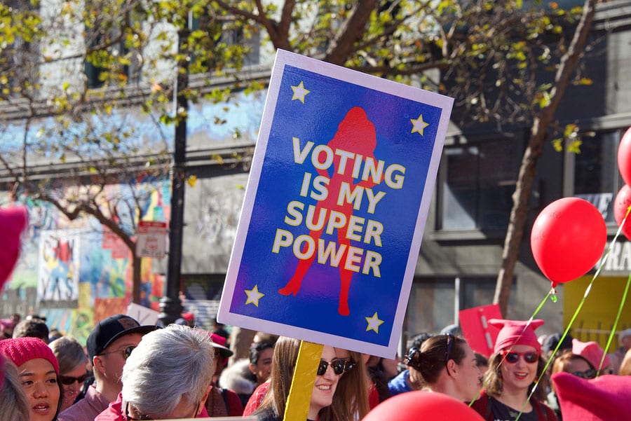 Woman holding sign in crowd that says Volting is my Super Power